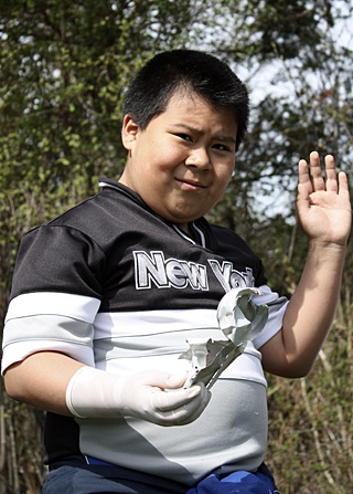 An Orcas Elementary student picking up garbage off the school grounds.