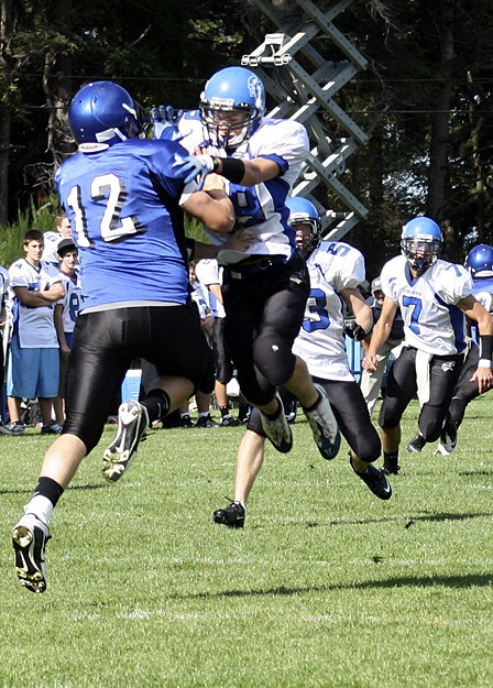 Viking Devon Stanzione (far right) goes to head to head with Christian Buck from Rainier Christian during the game on Oct. 2.