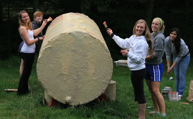 Members of the Orcas Key Club painting a new sign on the tank.