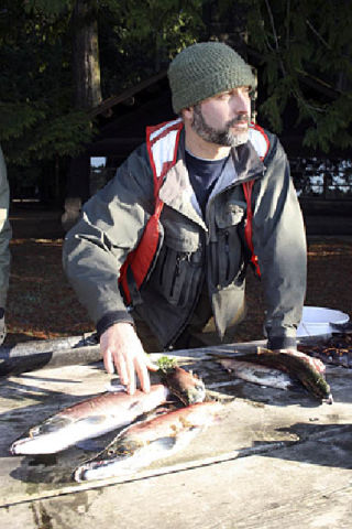 (Clockwise from top) A state Fish and Wildlife biologist cuts open a Kokanee trout harvested from Cascade Lake early Wednesday