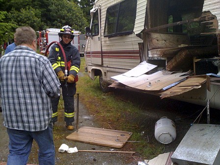 Dave Mowrey (back to the camera) and firefighter John Howard at the scene of a motorhome explosion.