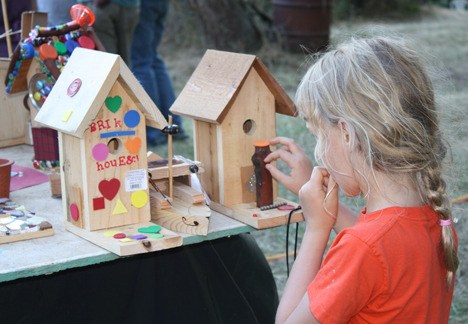 A young Woodsong attendee enjoys putting the finishing touches on her birdhouse at the craft tent.