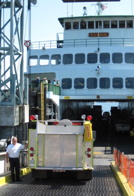 Fire chief Mike Harris bids farewell to Engine 22 as it boards the Elwha.