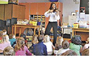 Violinist Monique Mead working with early elementary students this past spring.