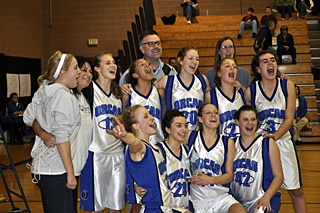 Orcas girls basketball team celebrating their first place win at the Tri-district championship on Saturday