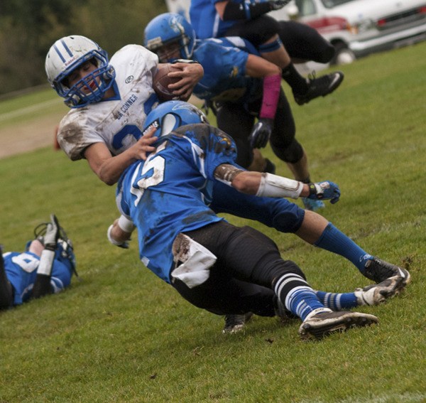 Viking senior Rylan Date tackling a La Conner player.