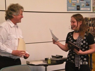 Training Division Chief Patrick Shepler presents new fire recruit Jamarra Ray Lowry with the Excellence in Achievement Award during a school assembly.