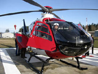 Top right: The Airlift Northwest helicopter on the landing field.  Above: Randy Nash of Airlift Northwest flies the new emergency response helicopter serving the San Juans to Orcas for a drill on Saturday.