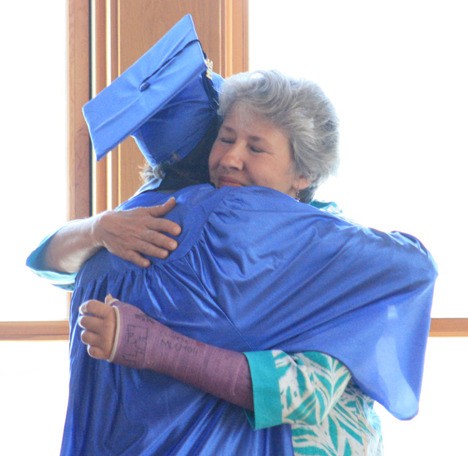 OASIS teacher Marta Branch receives a hug from new graduate Noah Sheppard.
