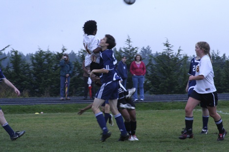 Lobo Solomon Bill fights to head the ball against a North Sound Christian defender.