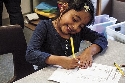 First grader Lluvia Qunitero works on an assignment in Homework Club