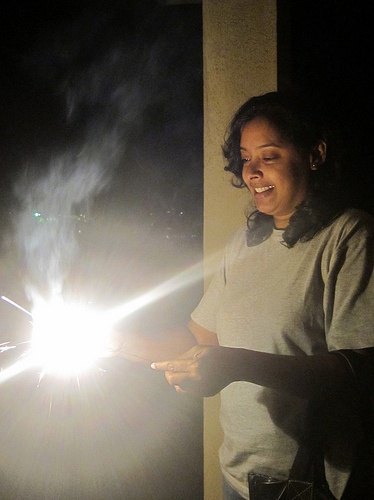 A woman lights a sparkler.