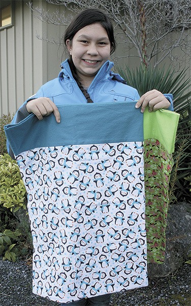 Kylar Dhaliwal with her hand-made pillowcases. She is donating 20 percent of proceeds to the animal shelter.