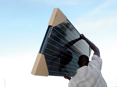 A local man carries a solar panel on the island of Chole