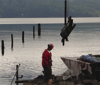 DNR contractors remove a derelict dock and creosote-treated pilings from Judd Cove on Orcas Island.