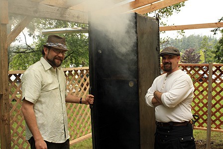 Mac Smith and Everett Brooks with their meat smoker.