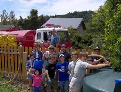 FEAST kids help the Orcas fire department fill up the water tank at the Eastsound FEAST garden.