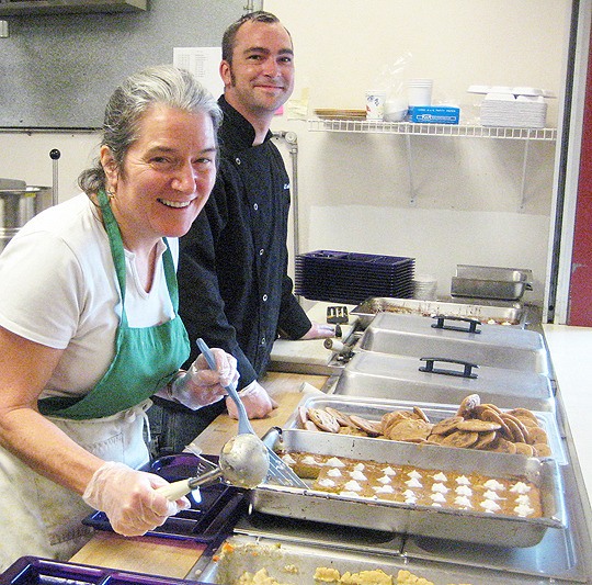 Anne Garfield serving along side school cafeteria chef