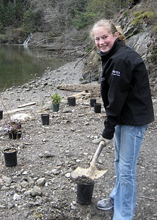 Tika Zbornick planting trees at the Judd Cove property on Orcas.