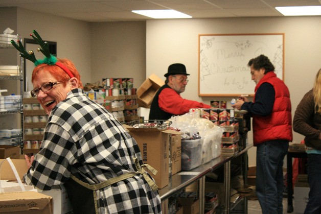 Food bank volunteer Maggie Kaplan sported a bit of holiday cheer as she and other helpers got ready to serve patrons.