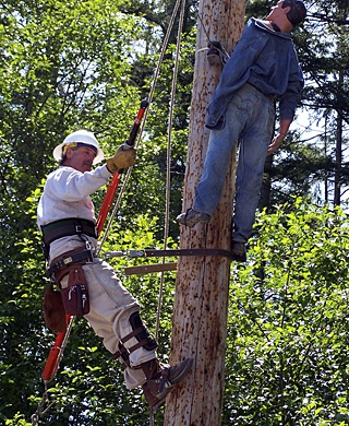 Journeyman Lineman Russ Hebert gets ready to lower the “hurt man” dummy during a pole top rescue exercise