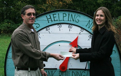 Food Bank president Larry Shaw receives a check from Victoria Shaner
