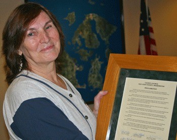 Helen Venada displays a proclamation signed by the County Council