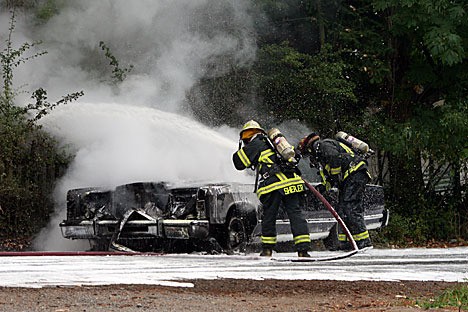 Firefighters Patrick Shepler and Chad Kimple douse the blaze.