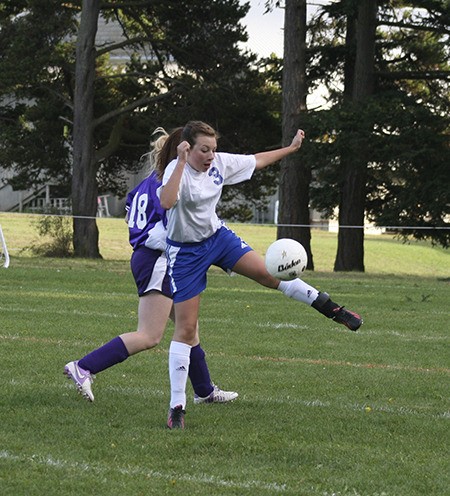 Player #3 leaps up to kick the ball