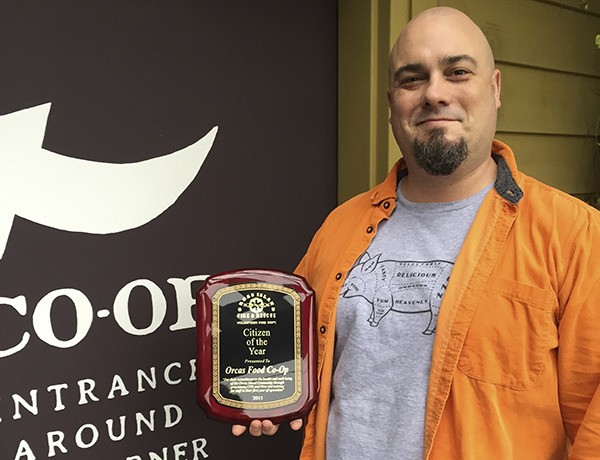 Assistant Manager Madden Surbaugh with award behind the Co-op.