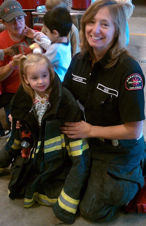Firefighter Maxx Jones shows Emma Lewis some real firefighter gear.