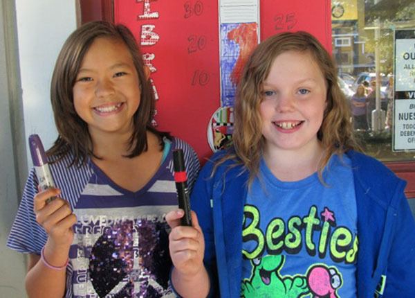 Sabrina Bailey (left) and Madison Todd (right) were top sellers in the “Unwrap the Library” drive. They are pictured above filling out the fundraising thermometer.
