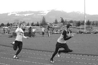 Sebastian Lasbo hands baton off to Jordan Smith in the boys’ 4 x 100m relay in Mt. Vernon on April 16. The Lopez boys’ relay team set a new school record time of 46.8 seconds.