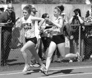 Lindsey Cummins hands off the baton to Laura Strom in the 4 x 200m relay at the State meet in Cheney