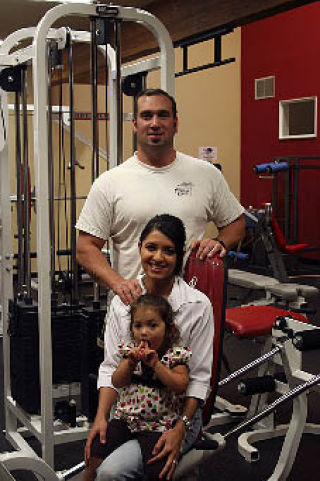 In the weight room at the Orcas Spa and Athletics new owners Thaddeus and Angela Douglas with daughter Isabella.