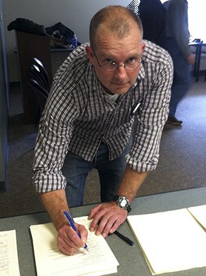 Orcas Recycling Services Director Pete Moe signing the contract.