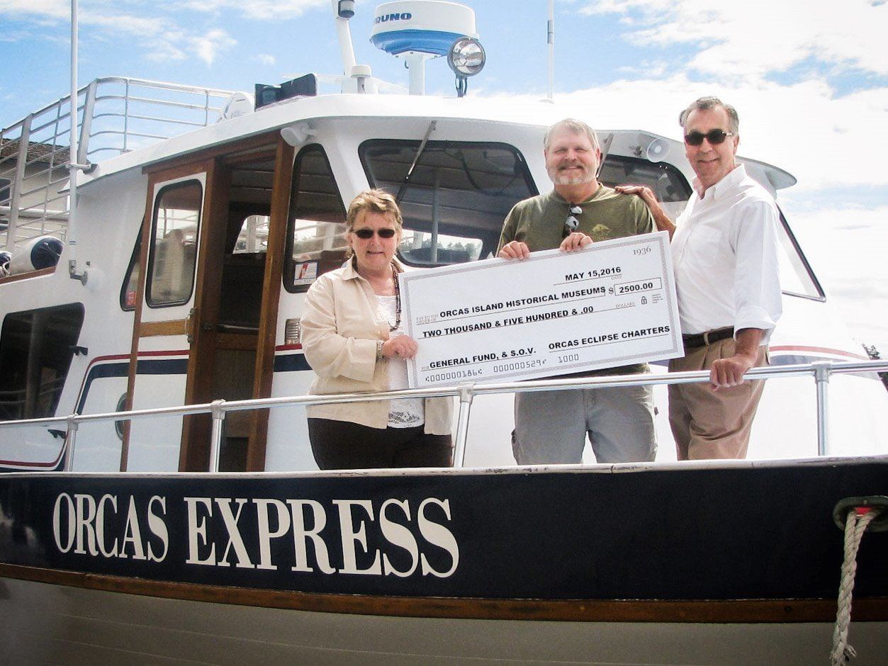 Denise and Dan Wilk giving a check to Clark McAbee (middle).