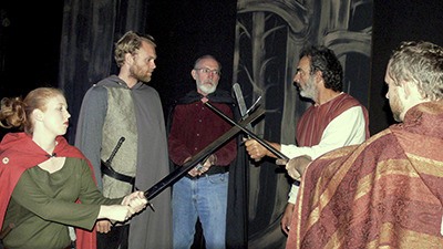 The cast rehearses with swords. L-R: Kate Hansen