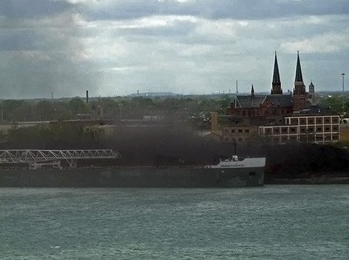 The wind picked up dust from the open-air petroleum coke pile on the side of the Detroit  River as the 'petcoke' was loaded onto the Manitowoc (photo taken on May 14