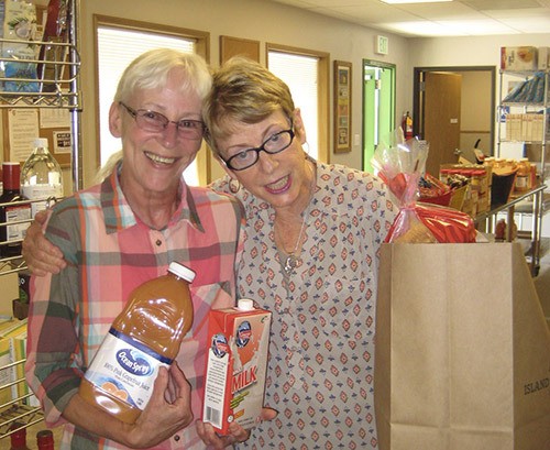 Food Bank Manager Jeannie Doty and volunteer Joanne Cundy pack bags for Senior Outreach deliveries.