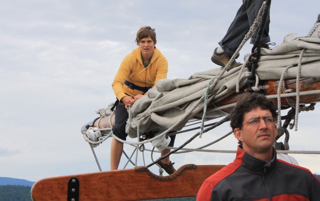 Young ship's crew taking in the sails at the end of a trip.