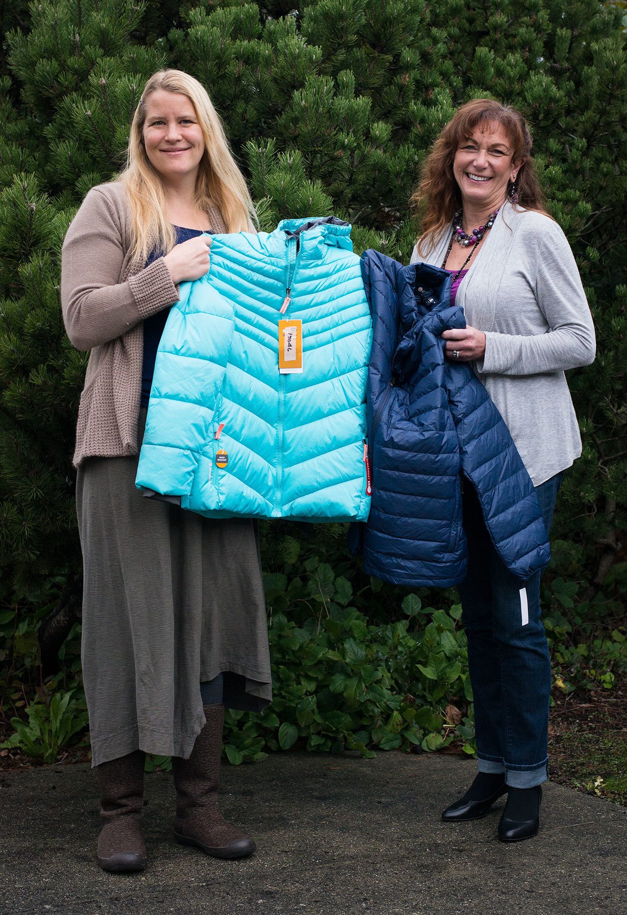 Orcas Family Connections Director Erin O’Dell (left) and Orcas Medical Center staff member Pat Ayers show two of the purchased coats.