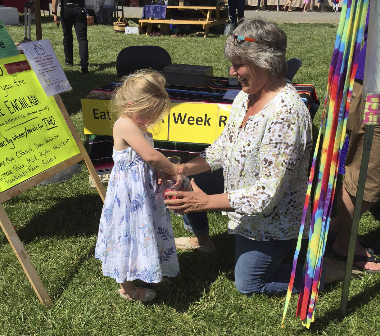 Preschool student Maggie with help from Children’s House director, Susan Anderson, pulls the winning ticket at last year’s drawing.