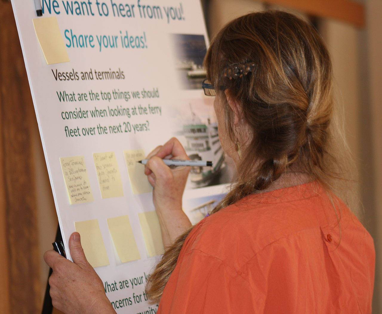Staff photo/Hayley Day                                A woman writes a suggestion for Washing State Ferries’ long-range plan at an open house in Friday Harbor.