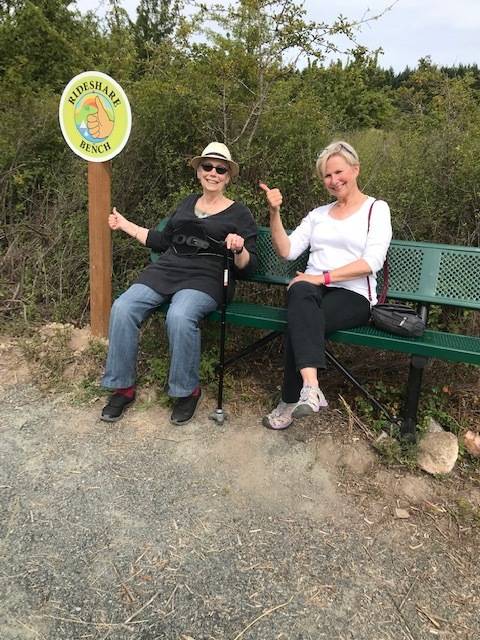 Contributed photo                                Graphic Artist Ginna Magee, designer of the Ride Share sign, and Sheila Gaquin practice hitching a ride.