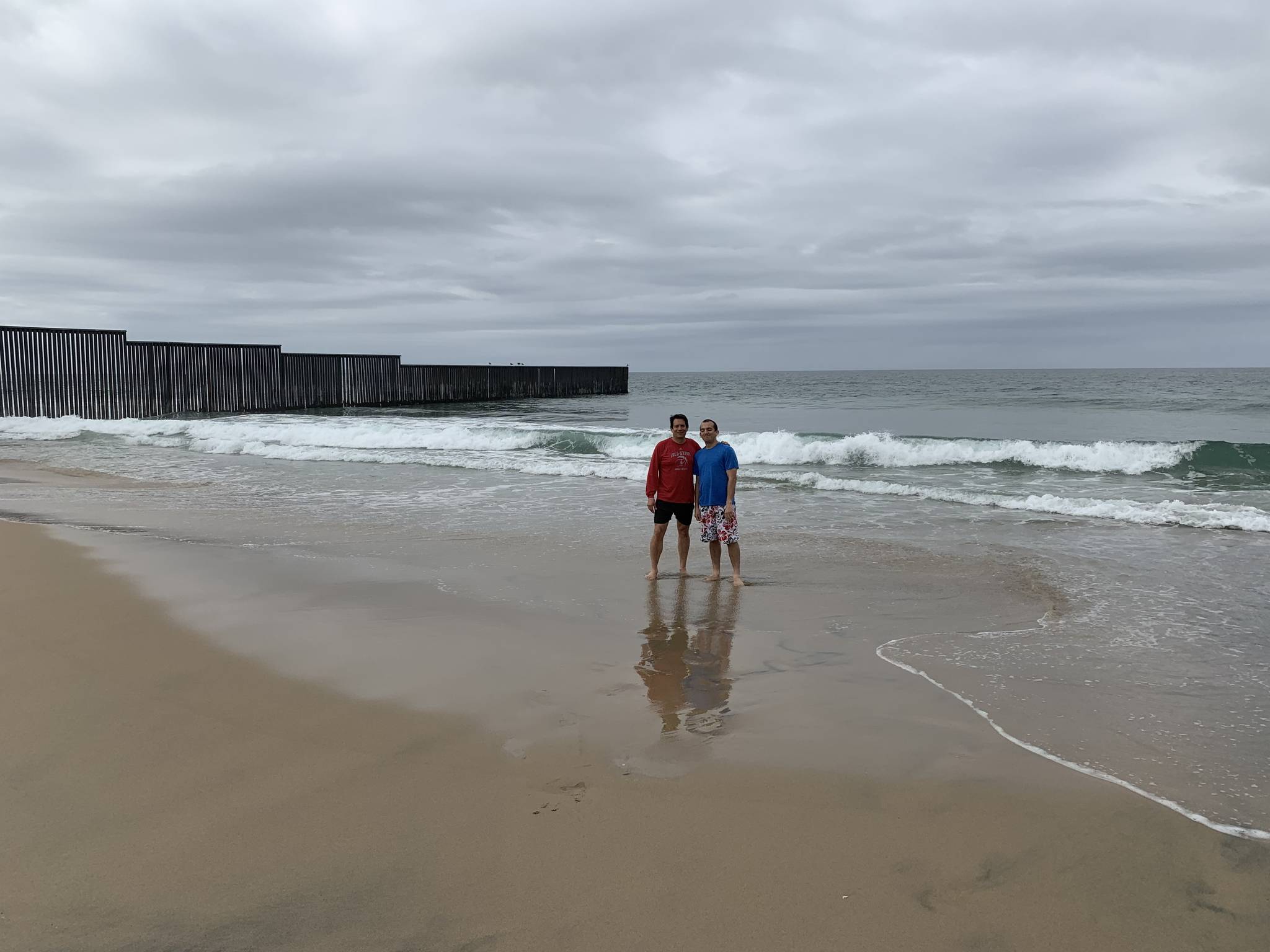 Paul Pineda and his son Nick at the start of the border wall on the Pacific coast