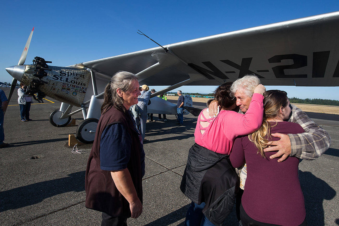 As his wife Heather looks on, John Norman gets a hug from his daughter Amber Nelson, and granddaughter Ashlee Nelson, right, after his replica of the Spirit of St. Louis flew for the first time from Arlington Municipal Airport on Sunday, July 28, 2019 in Arlington, Wash. (Andy Bronson / The Herald)