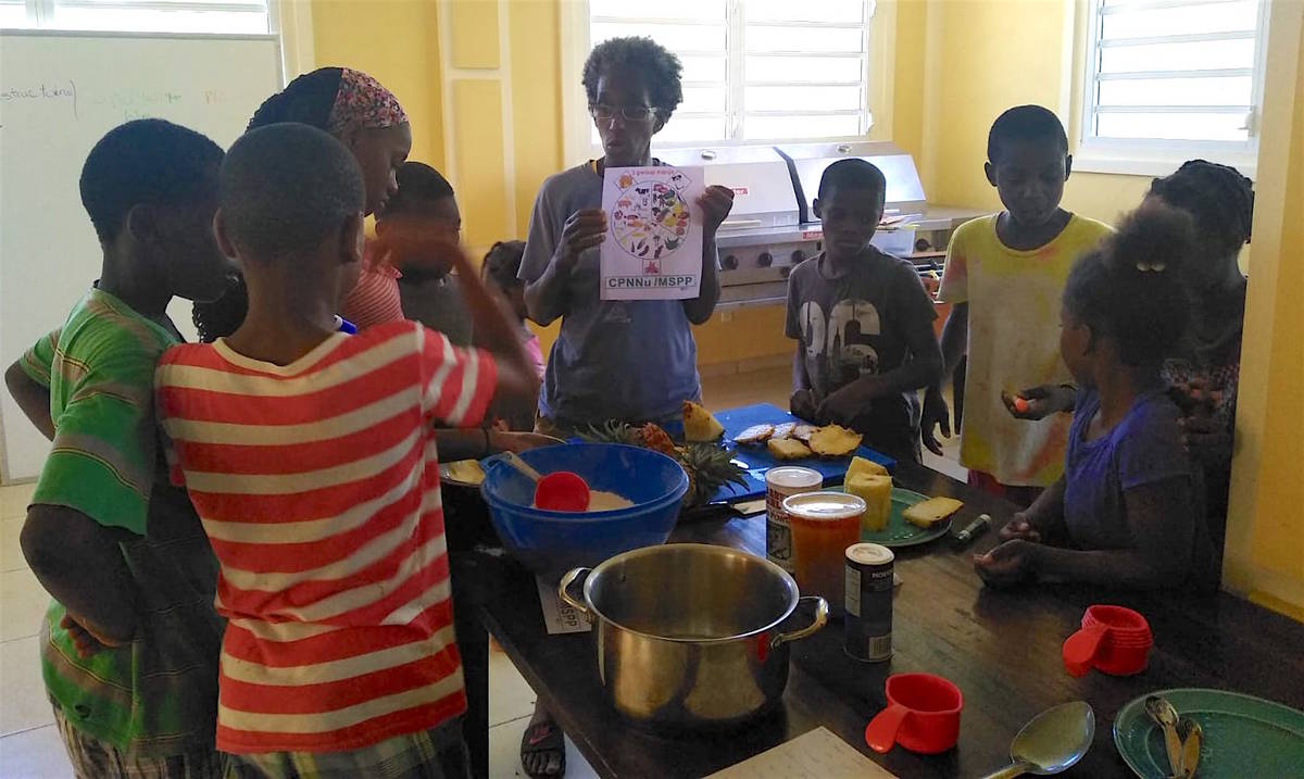 Contributed Photo | Rosedanie Cadet and children at an orphanage in Mirebalais, Haiti make upside-down pineapple cake.
