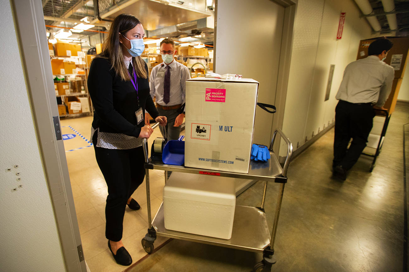 UWMC Pharmacy Manager Christine Meyer puts a tray of 975 doses of Pfizers coronavirus vaccine into the deep freeze after the vaccine arrived at UW Medicines Montlake campus Monday morning, Dec. 14, 2020. These are among the first to be distributed in Washington state. A total of 3,900 doses arrived at the UW on on Dec. 14 that will be distributed among UW Medicines four hospital campuses. (WA DOH POOL/contributed photo)