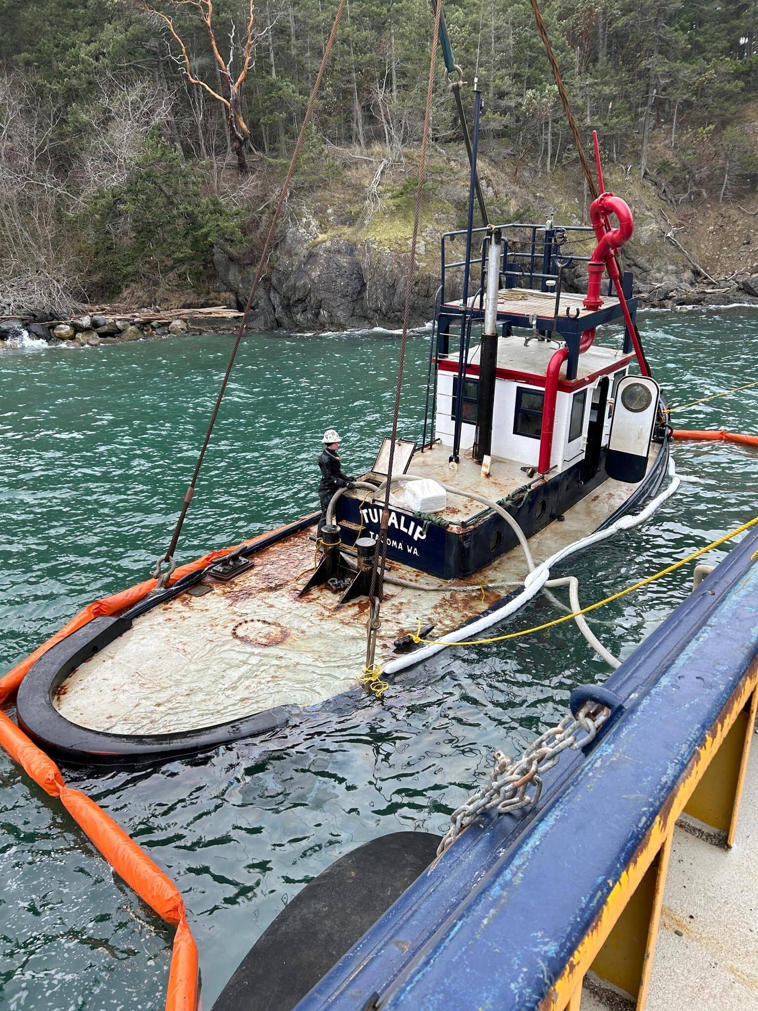 Contributed photo.
The partially submerged Tugboat Tulalip is suspended alongside a response vessel near the Lopez ferry terminal in preparation for removal.